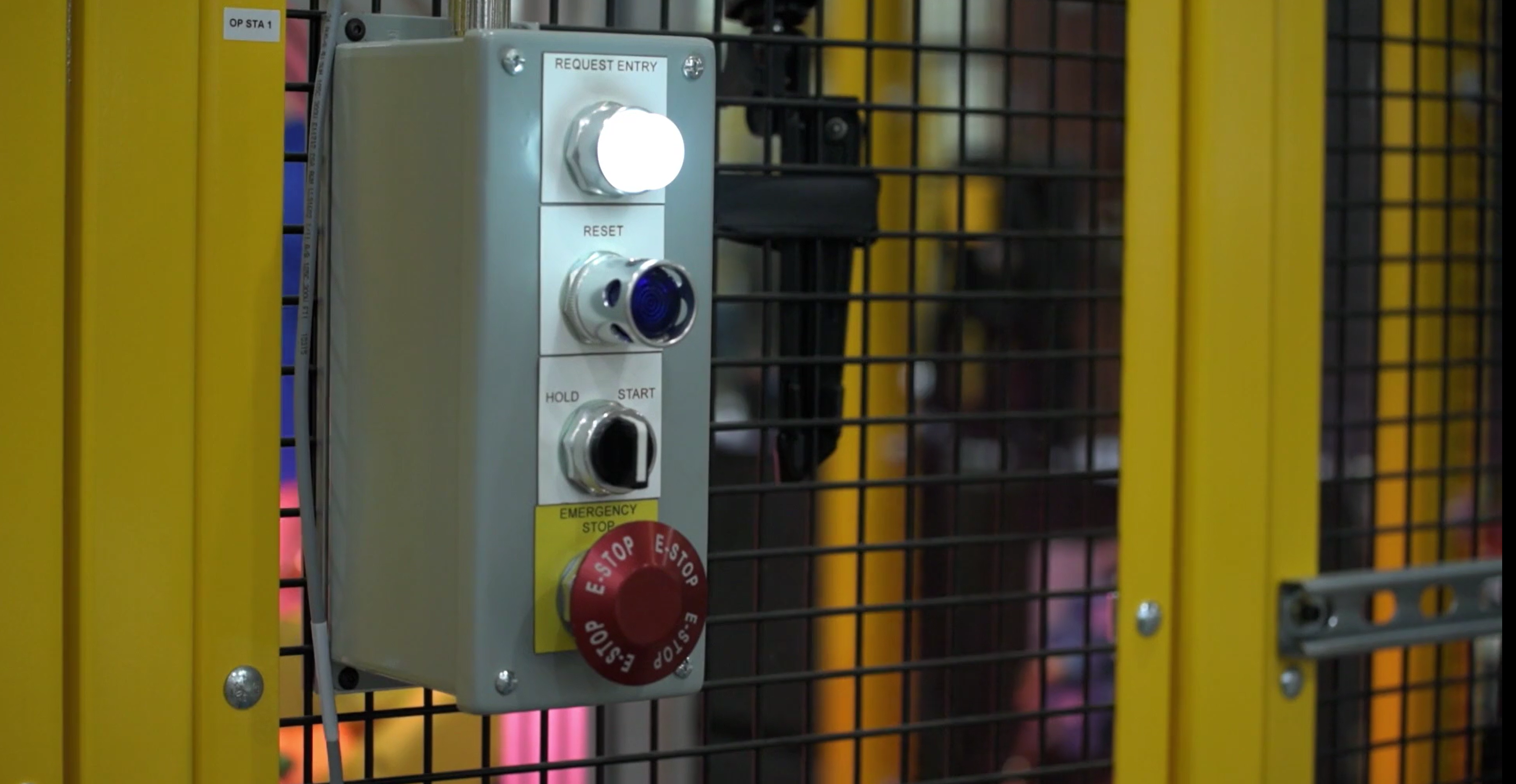Picture of a safety cage with pushbuttons surrounding a machine.