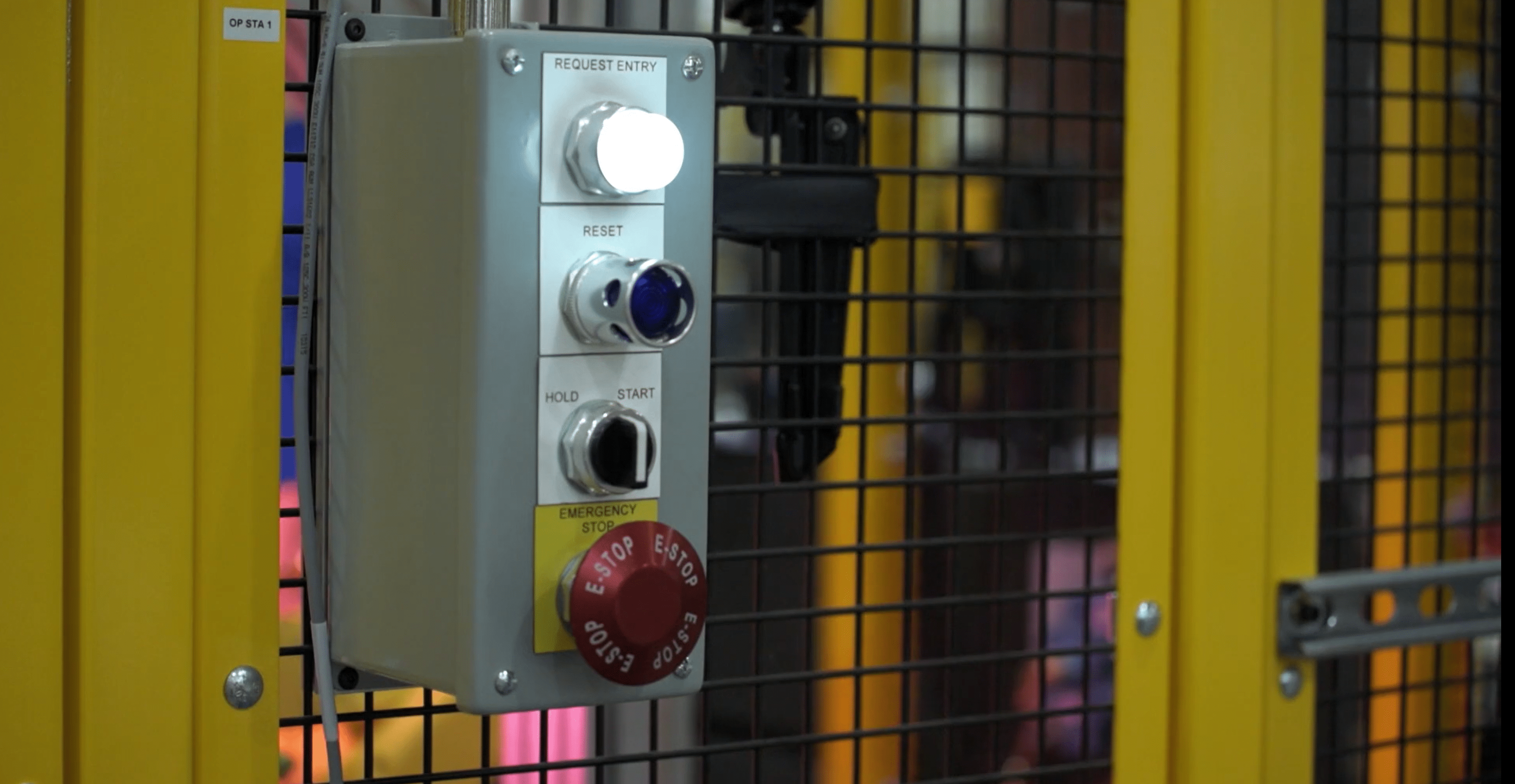 Picture of a safety cage with pushbuttons surrounding a machine.