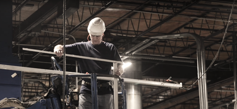 Image of an electrician replacing lighting fixture in a industrial plant.
