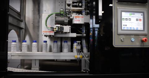 Bottles running through a labeling machine.