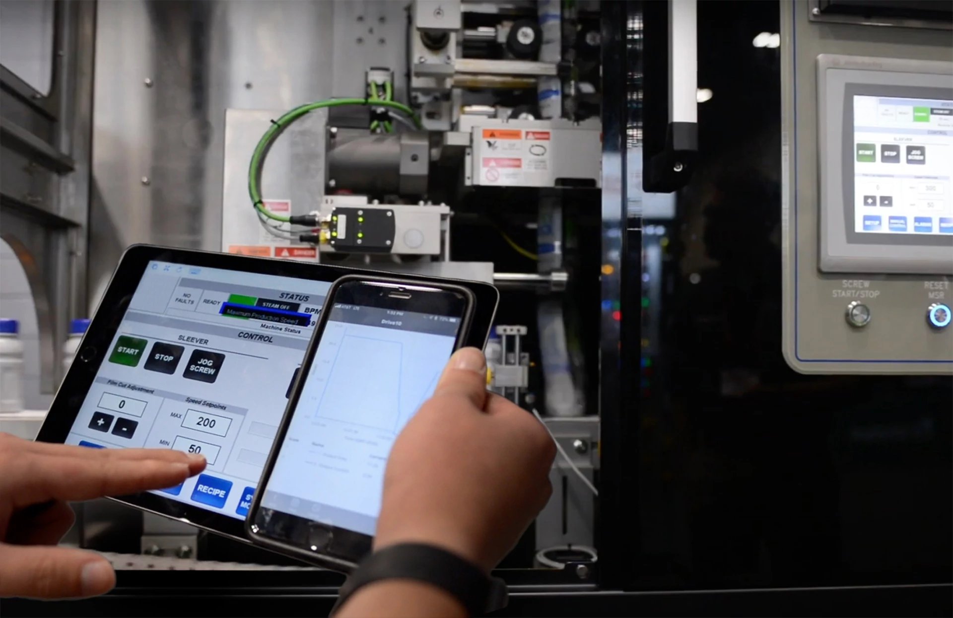 Worker with a tablet or iPad checking status of a machine using mobile tools