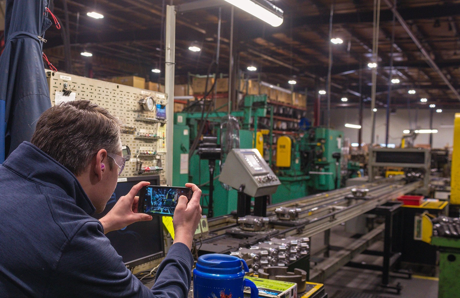 Photo of employee taking pictures inside of a manufacturing company for use in a lighting audit.